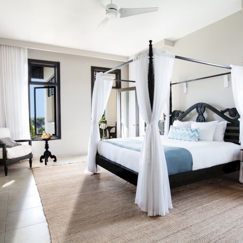 A bright, airy living area with a light wood floor, white walls, a gray sofa, and a skylight-filled ceiling; a dining nook and modern d&eacute;cor.